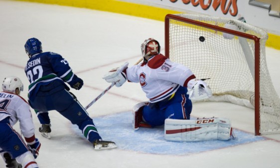 Vancouver Canucks' Daniel Sedin, left, of Sweden, scores the winning goal against Montreal Canadiens goalie Carey Price during overtime NHL hockey action in Vancouver, B.C., on Thursday October 30, 2014. THE CANADIAN PRESS/Darryl Dyck