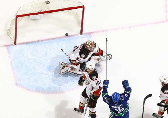 VANCOUVER, BC - JANUARY 1: the puck sits in the net behind Frederik Andersen #31 of the Anaheim Ducks as Derek Dorsett #15 of the Vancouver Canucks celebrates the goal of Christopher Tanev #8 during their NHL game at Rogers Arena January 1, 2016 in Vancouver, British Columbia, Canada. Vancouver won 2-1. (Photo by Jeff Vinnick/NHLI via Getty Images)