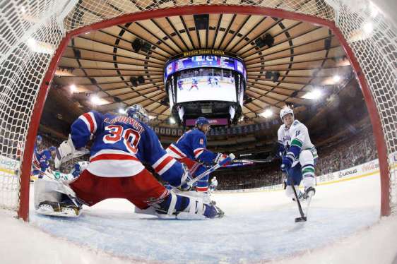 NEW YORK, NY - JANUARY 19: Alex Burrows #14 of the Vancouver Canucks redirects the puck into the net past Henrik Lundqvist #30 of the New York Rangers for a goal in the second period at Madison Square Garden on January 19, 2016 in New York City. (Photo by Jared Silber/NHLI via Getty Images)