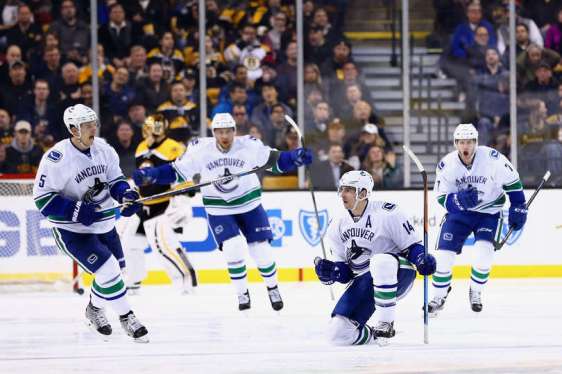 BOSTON, MA - JANUARY 21: Alex Burrows #14 of the Vancouver Canucks, second from right, celebrates wiht Luca Sbisa #5 and Linden Vey #7 after scoring against the Boston Bruins during the third period at TD Garden on January 21, 2016 in Boston, Massachusetts. The Canucks defeat the Bruins 4-2. (Photo by Maddie Meyer/Getty Images)