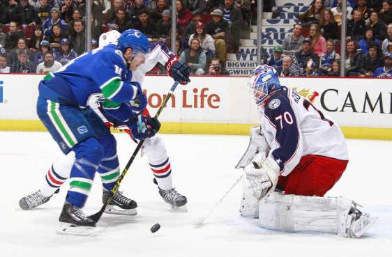 VANCOUVER, BC - FEBRUARY 4: Joonas Korpisalo #70 of the Columbus Blue Jackets makes a save on Alexandre Burrows #14 of the Vancouver Canucks during their NHL game at Rogers Arena February 4, 2016 in Vancouver, British Columbia, Canada. (Photo by Jeff Vinnick/NHLI via Getty Images)