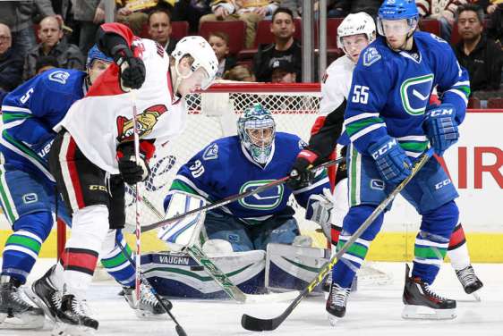 VANCOUVER, BC - FEBRUARY 25: Ryan Miller #30 of the Vancouver Canucks peers through a crowd for the puck during their NHL game against the Ottawa Senators at Rogers Arena February 25, 2016 in Vancouver, British Columbia, Canada. (Photo by Jeff Vinnick/NHLI via Getty Images)