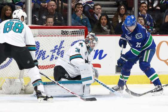 VANCOUVER, BC - FEBRUARY 28: Daniel Sedin #22 of the Vancouver Canucks bats at a loose puck for a goal on Martin Jones #31 of the San Jose Sharks as Brent Burns #88 of the Sharks watches during their NHL game at Rogers Arena February 28, 2016 in Vancouver, British Columbia, Canada. (Photo by Jeff Vinnick/NHLI via Getty Images)