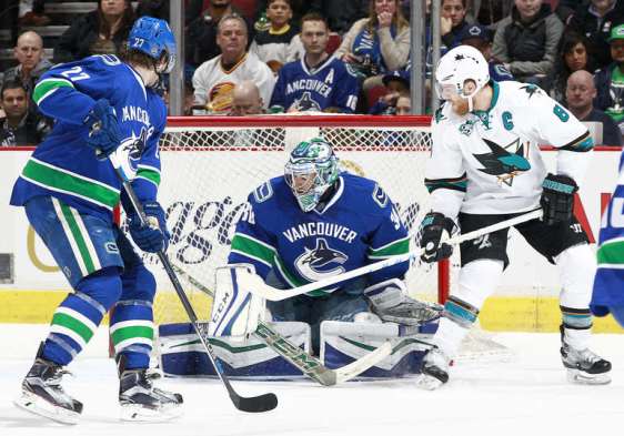 VANCOUVER, BC - FEBRUARY 28: Joe Pavelski #8 of the San Jose Sharks and Ben Hutton #27 of the Vancouver Canucks watch Ryan Miller #30 of the Canucks make a save during their NHL game at Rogers Arena February 28, 2016 in Vancouver, British Columbia, Canada. (Photo by Jeff Vinnick/NHLI via Getty Images)