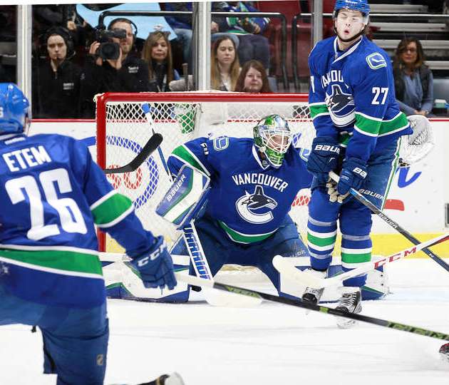 VANCOUVER, BC - MARCH 1: Ben Hutton #27 winces as Emerson Etem #26 and Jacob Markstrom #25 of the Vancouver Canucks follow the puck against the New York Islanders during their NHL game at Rogers Arena March 1, 2016 in Vancouver, British Columbia, Canada. (Photo by Jeff Vinnick/NHLI via Getty Images)