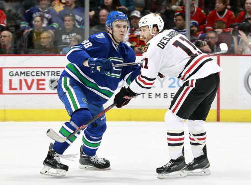 VANCOUVER, BC - MARCH 27: Nikita Tryamkin #88 of the Vancouver Canucks checks Andrew Desjardins #11 of the Chicago Blackhawks during their NHL game at Rogers Arena March 27, 2016 in Vancouver, British Columbia, Canada. (Photo by Jeff Vinnick/NHLI via Getty Images)