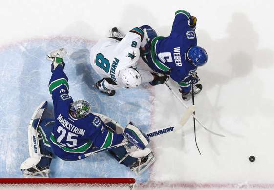 VANCOUVER, BC - MARCH 29: Jacob Markstrom #25 of the Vancouver Canucks makes a save while Joe Pavelski #8 of the San Jose Sharks and Yannick Weber #6 of the Canucks pursue the rebound during their NHL game at Rogers Arena March 29, 2016 in Vancouver, British Columbia, Canada. San Jose won 4-1. (Photo by Jeff Vinnick/NHLI via Getty Images)